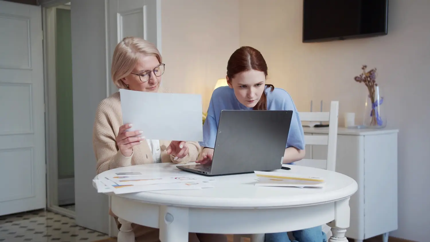 A woman helps her grandmother with work. They study documents and fill out tables on the computer. High quality 4k footage