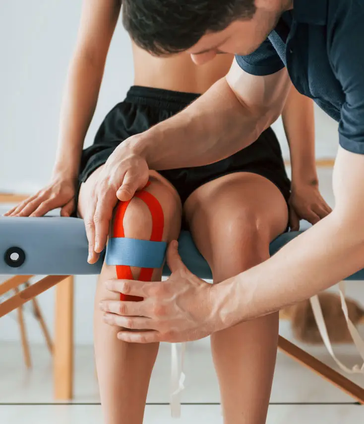 Physical Therapist applying kinesiology tape